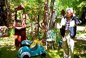Jean Hatfield surrounded by his yard art